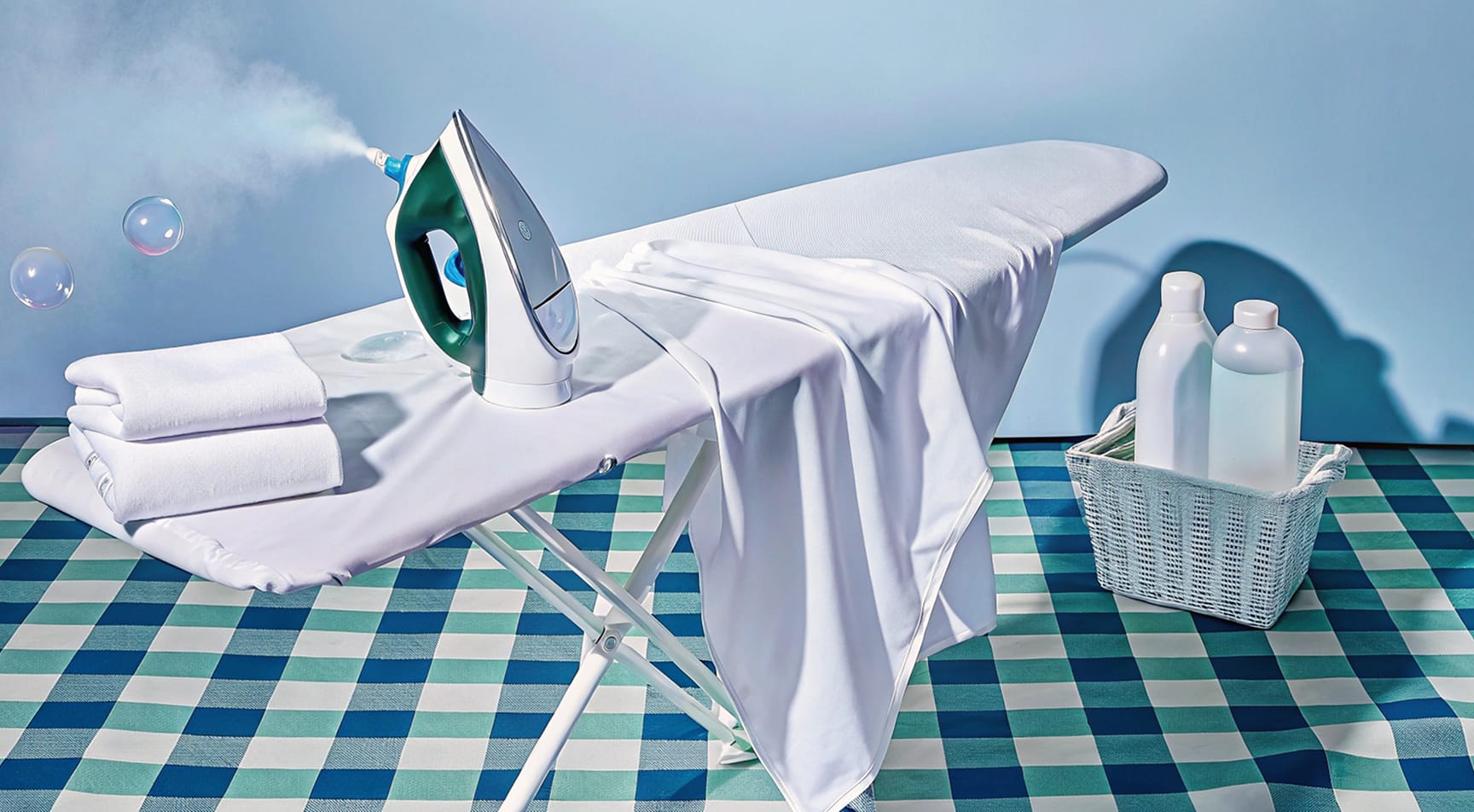 שירות גיהוץ מקצועי - מגהץ אדים על קרש גיהוץ עם חולצה מגוהצת למשעי